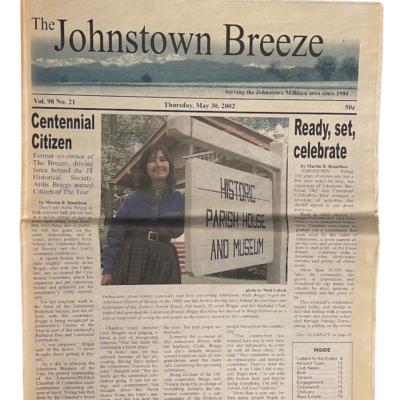 A photo of the front page of The Johnstown Breeze newspaper from May 30, 2002 featuring Ardis Briggs-Tomlinson as Centennial Citizen with a photo of her standing in front the Historic Parish House and Museum.