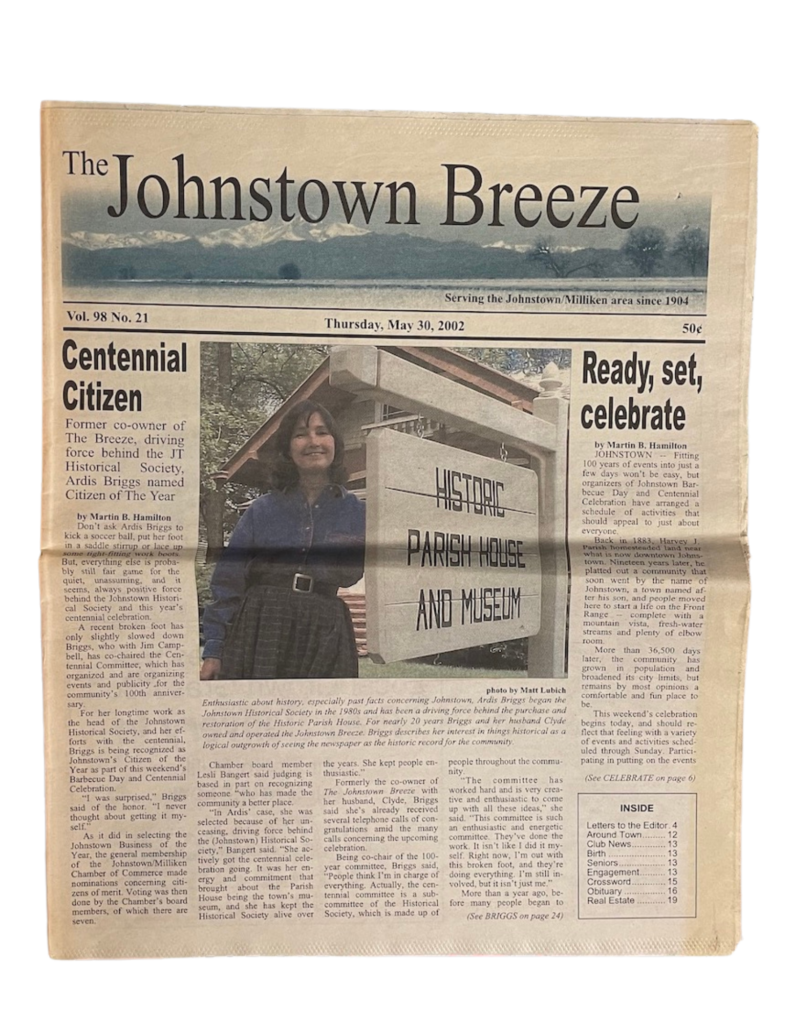 A photo of the front page of The Johnstown Breeze newspaper from May 30, 2002 featuring Ardis Briggs-Tomlinson as Centennial Citizen with a photo of her standing in front the Historic Parish House and Museum.