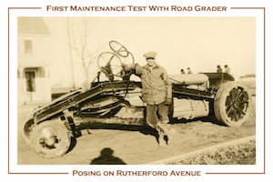 A postcard featuring the first maintenance test with a road grader.  Shown is a man standing in front of a large vehicle.