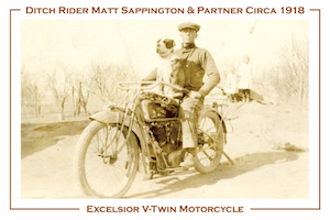 A postcard featuring ditch rider, Matt Sappington and partner, circa 1918.  Shown is a man riding an old-fashinoned electric bike with a dog sitting on his lap.