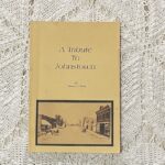 A photo of an older book titled, "A Tribute To Johnstown" by Rebecca S. Healy. The cover features and old photo of Johnstown's main street.